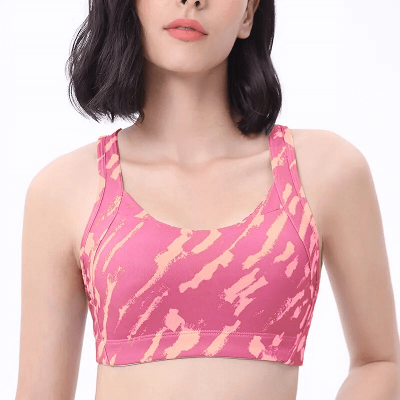 Model wearing a pink Stylish Elastic Sports Bra with Cross Back for Women, showcasing breathable Nylon+Spandex fabric and comfort fit.